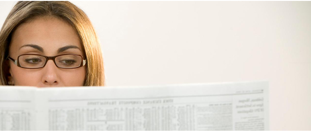 female trader reading her newspaper to get updated before the working day starts